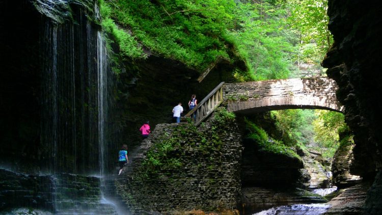 People hiking over bridge in Watkins Glen State Park - Things to do in UpState New York