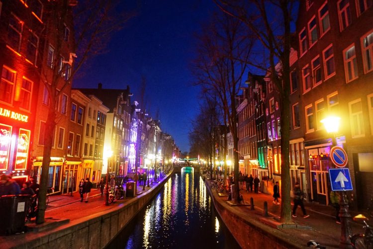 Bright colorful lights along the streets of Amsterdam's Red Light District at night