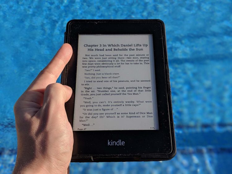 Man with a hand on his Kindle on a sunny day