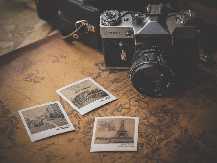 Polaroids of European destinations and a camera on top of a world map